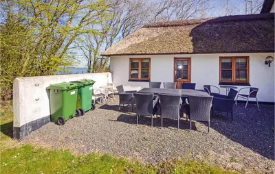 a table and chairs in front of a house at Venøhus in Struer