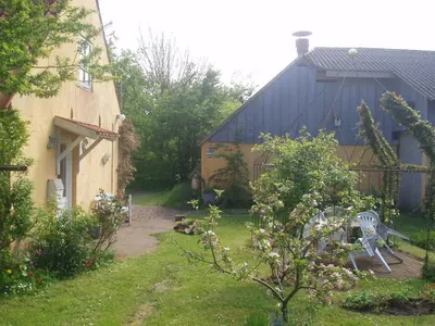 a garden with a building and a yard with a chair at Country house in Karby