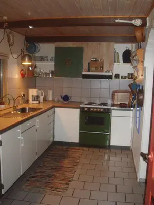 a kitchen with a green stove and a sink at Country house in Karby