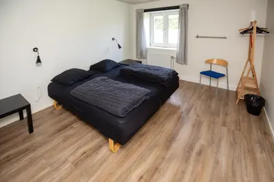 a bedroom with a large bed and a wooden floor at Bed and Breakfast Lemvig in Lemvig