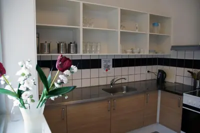 a kitchen with a sink and a vase of flowers at Motel Skive in Skive