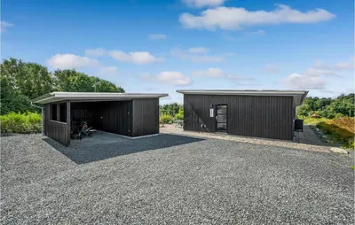 two buildings on gravel with trees in the background at Three-Bedroom Holiday Home In Spottrup in Spottrup