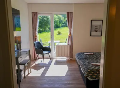 a room with a bed and a desk and a window at Hotel Limfjorden in Thisted