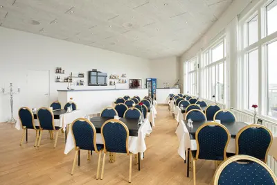 a conference room with tables and chairs and windows at Hotel Limfjorden in Thisted