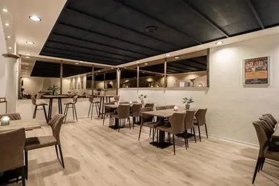 a restaurant with tables and chairs in a room at Hotel Limfjorden in Thisted