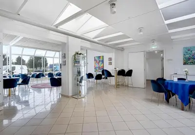 a banquet hall with blue tables and chairs at Hotel Søparken in Åbybro