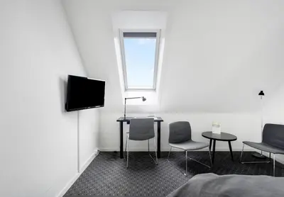 a room with a table and two chairs and a television at Hotel Søparken in Åbybro