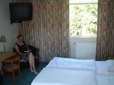 a woman sitting in a chair in a hotel room at St. Binderup Kro in Store Binderup