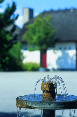 a blue fountain with water pouring out of it at St. Binderup Kro in Store Binderup