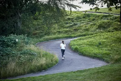 a woman walking down a path in a field at HimmerLand in Gatten