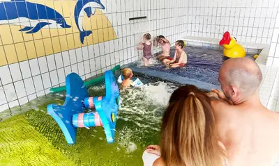 a group of children playing in an indoor swimming pool at HimmerLand in Gatten