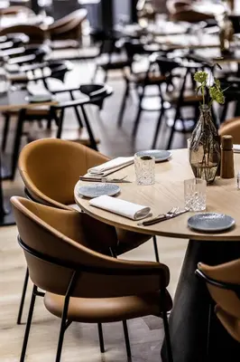 a wooden table with chairs and a vase of flowers at HimmerLand in Gatten