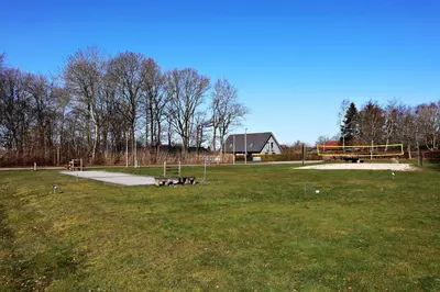 a park with benches and a playground in a field at Plexus Hytterne in Holstebro