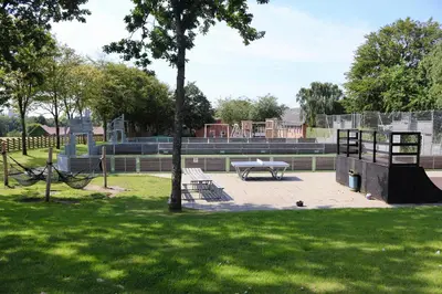 a park with a picnic table and a playground at Plexus Hytterne in Holstebro