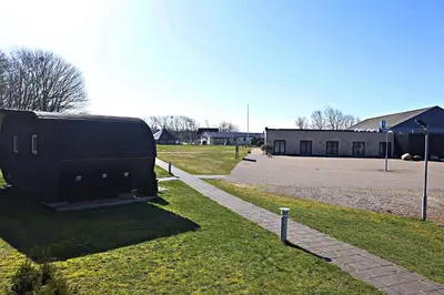a building sitting in the grass next to a street at Plexus Hytterne in Holstebro