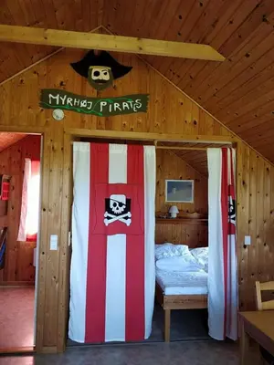 a bedroom with a bed in a wooden cabin at Myrhoj Camping in Myrhøj