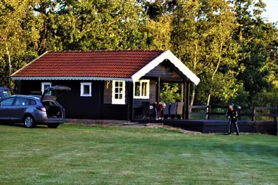 a man standing in front of a small cabin at Myrhoj Camping in Myrhøj