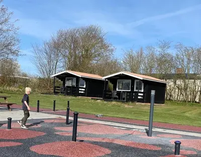 a young boy walking in front of a building at Myrhoj Camping in Myrhøj