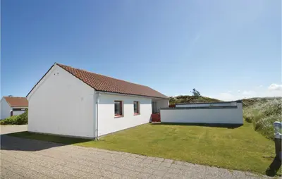 a white house with a yard with a fire hydrant at Two-Bedroom Holiday Home In Pandrup in Pandrup
