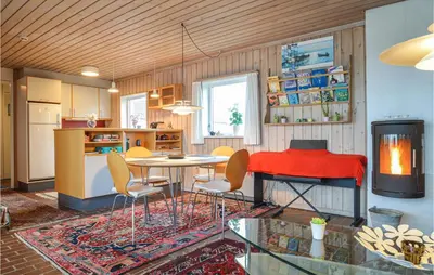 a living room with a table and chairs and a kitchen at Two-Bedroom Holiday Home In Pandrup in Pandrup