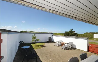 a patio with chairs and a table on a white wall at Two-Bedroom Holiday Home In Pandrup in Pandrup