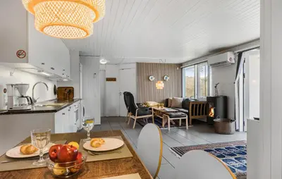 a kitchen and living room with a table and chairs at Three-Bedroom Holiday Home In Pandrup in Pandrup