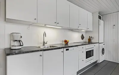 a white kitchen with white cabinets and a sink at Three-Bedroom Holiday Home In Pandrup in Pandrup