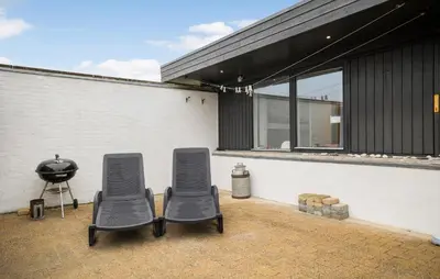 two chairs and a grill on a patio at Three-Bedroom Holiday Home In Pandrup in Pandrup