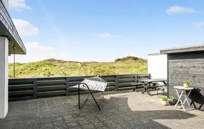 a patio with two chairs and a table and a fence at Two-Bedroom Holiday Home In Pandrup in Pandrup