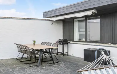 a patio with a table and chairs and a grill at Two-Bedroom Holiday Home In Pandrup in Pandrup