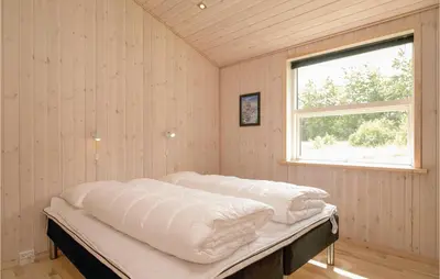 a bed in a room with a window at Four-Bedroom Holiday Home In Lokken in Løkken