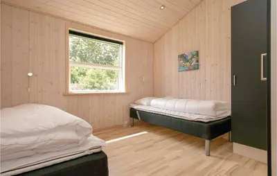 a bedroom with two beds and a window at Four-Bedroom Holiday Home In Lokken in Løkken