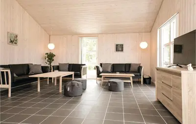 a living room with couches and tables in a room at Four-Bedroom Holiday Home In Lokken in Løkken