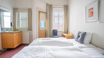 a hotel room with two beds and a desk at Palads Hotel in Viborg