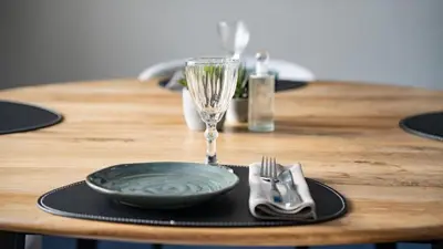 a wooden table with a plate and a wine glass at Palads Hotel in Viborg