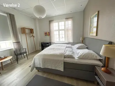 a bedroom with a large bed in a room at Hotel Højslev Kro in Højslev
