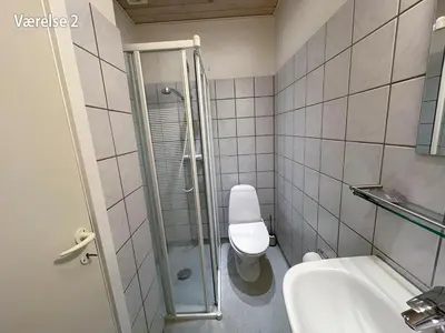 a bathroom with a toilet and a sink and a shower at Hotel Højslev Kro in Højslev