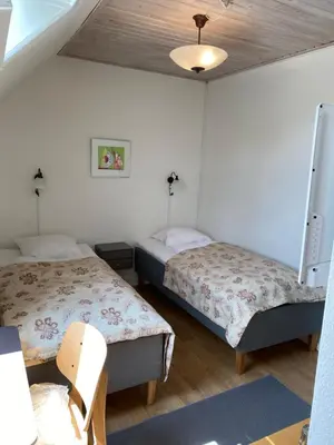 a room with two beds and a chair in it at Hotel Højslev Kro in Højslev
