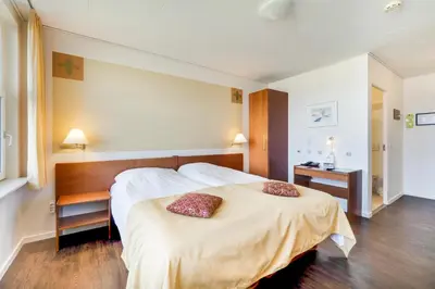 a bedroom with a large bed with two pillows on it at Hotel Pinenhus in Glyngøre