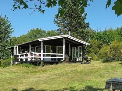 a house on a hill with a grassy field at 4 person holiday home in Højslev in Højslev