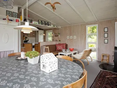 a kitchen and living room with a table and chairs at 4 person holiday home in Højslev in Højslev