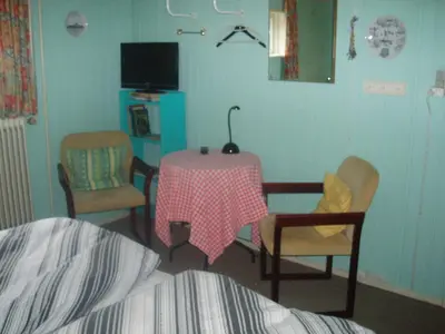 a bedroom with a table and chairs and a tv at Glyngøre Bed & Breakfast in Glyngøre