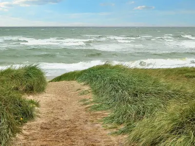 a dirt path on the beach with the ocean at 5 person holiday home in Lemvig-By Traum in Trans