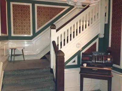 a hallway with a staircase and a table with a desk at Hotel Lidenlund in Lemvig