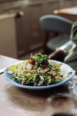 a plate of food with a salad on a table at Hotel Lidenlund in Lemvig