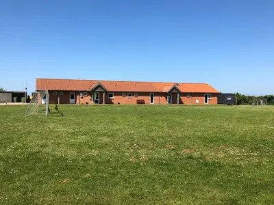 a field with a soccer goal in front of a building at Danhostel Fjaltring in Fjaltring