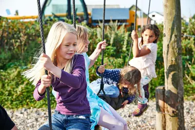 a group of children playing on a playground at Danhostel Fjaltring in Fjaltring