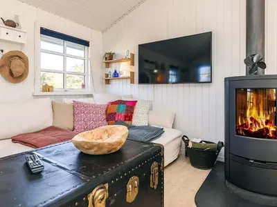 a living room with a couch and a fireplace at 6 person holiday home in Løkken-By Traum in Løkken