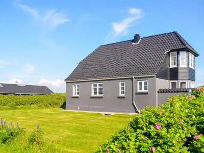 a gray house with a black roof on a yard at 6 person holiday home in Lemvig in Ferring