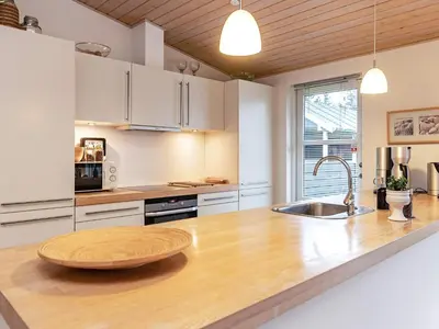 a kitchen with a wooden counter top with a sink at Modern Retreat with Spa - By Traum Ferienwohnungen in Løkken